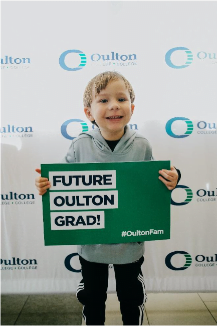 kid holding an oulton poster