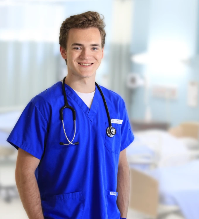 Bachelor of Science in Nursing Male Student, from Oulton College in his scrubs during a hands-on experience practical/ class. Oulton College Nursing School.