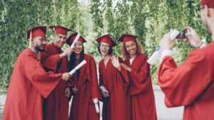 Graduating Highschool students in their red graduation robes. Associates Degree in Business Administration is a path way for students to avoid burnout and increase their ROI