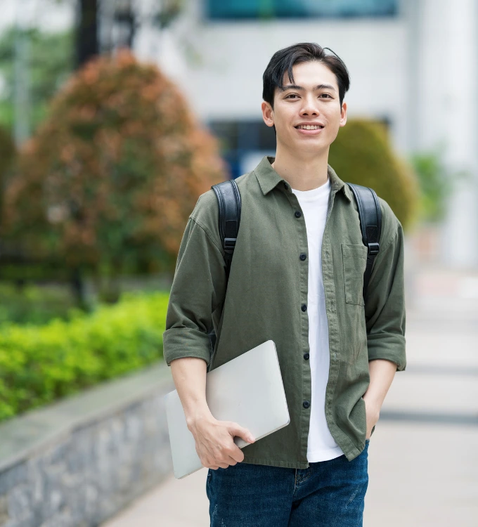 Business Management and Entrepreneurship Student, wearing a green shirt and jeans. Student has a book in his hand and a bag on his shoulders