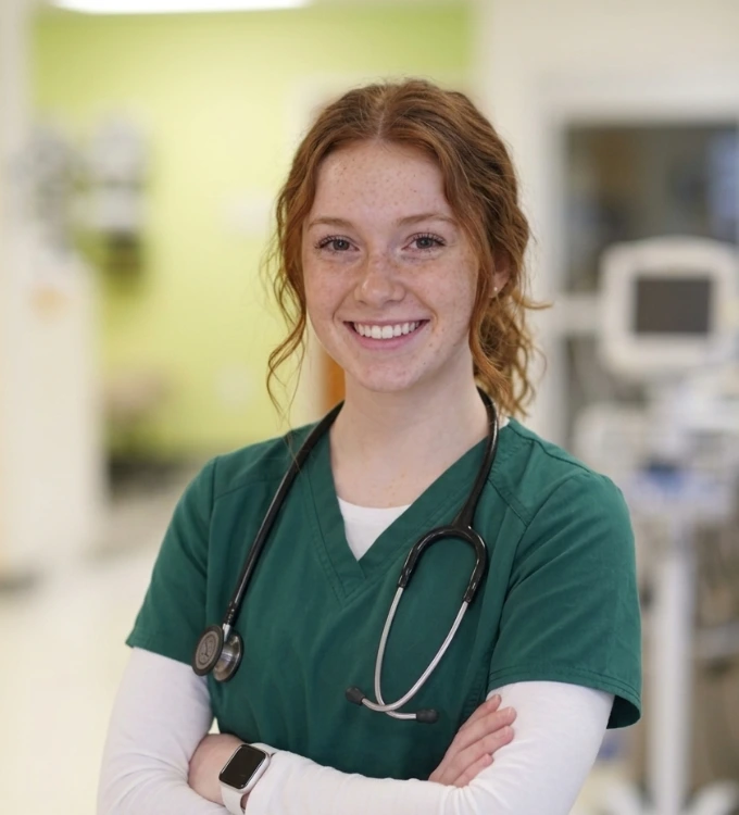 Bachelor of Science in Nursing student in the Nursing lab. Student is smiling in her scrubs.